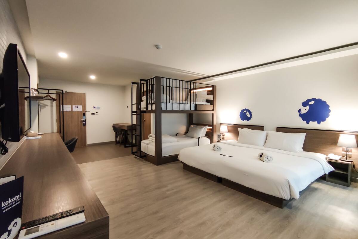Ein Hotelzimmer mit einem Etagenbett, einem Schreibtisch und einem Fernseher.