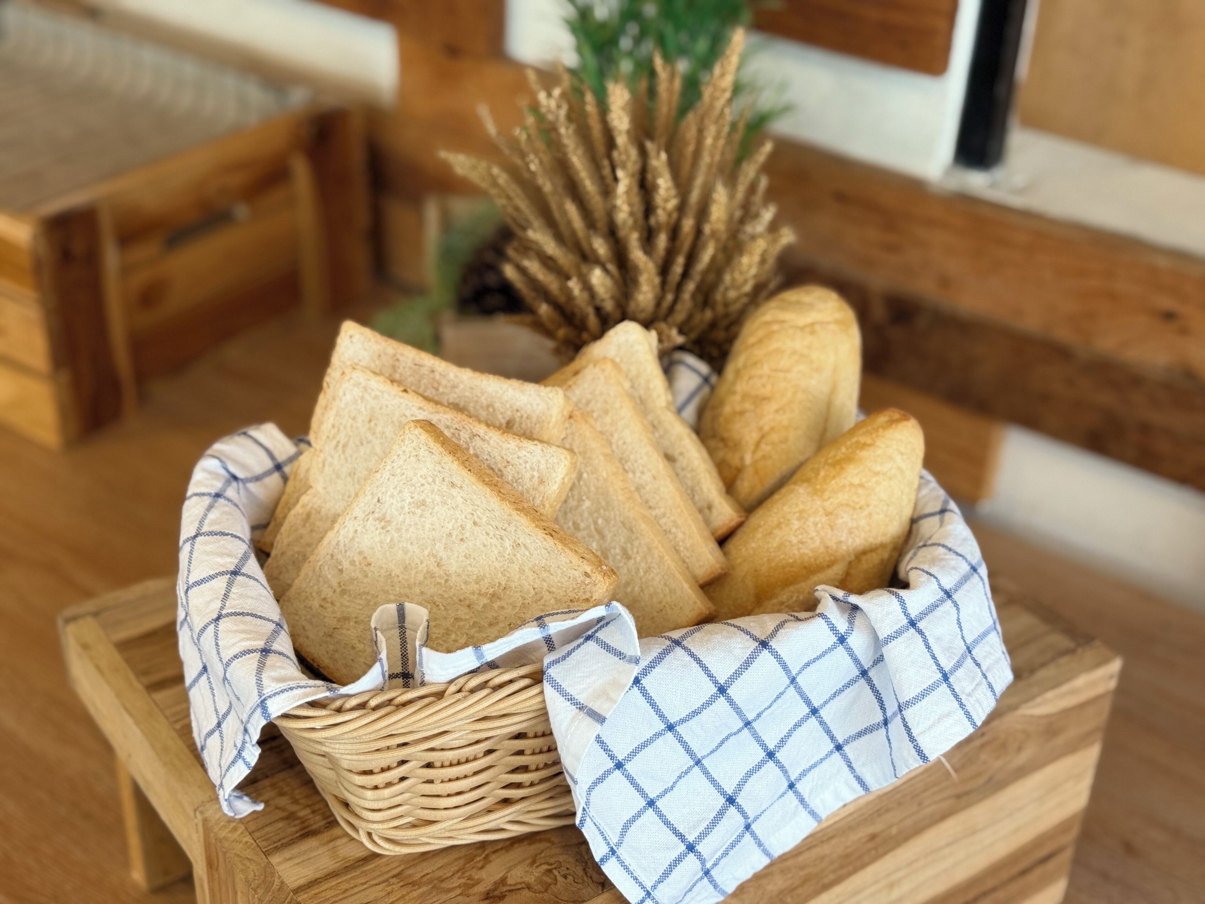A wicker basket with bread on a wooden table.
