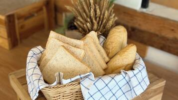 A wicker basket with bread on a wooden table.