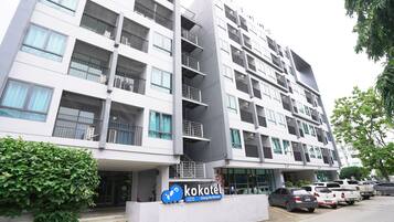 A modern building with multiple floors, balconies, and a sign for 'Kokotel'.