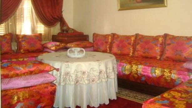 A room with a sofa set, a round table with a white tablecloth, and a painting on the wall. - Appartement 2 Chambre Ville Nouvelle Fes (Fes)