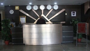 Una recepción con varios relojes, un cartel que dice "RECEPTION" y un letrero que dice "BIENVENIDOS A".