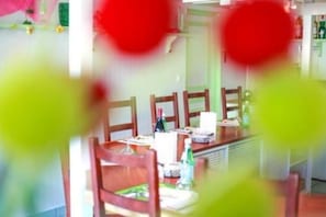 A dining area with wooden chairs and tables, a whiteboard, and various items on the tables. - Fasthôtel Tours Nord (Parcay-Meslay)