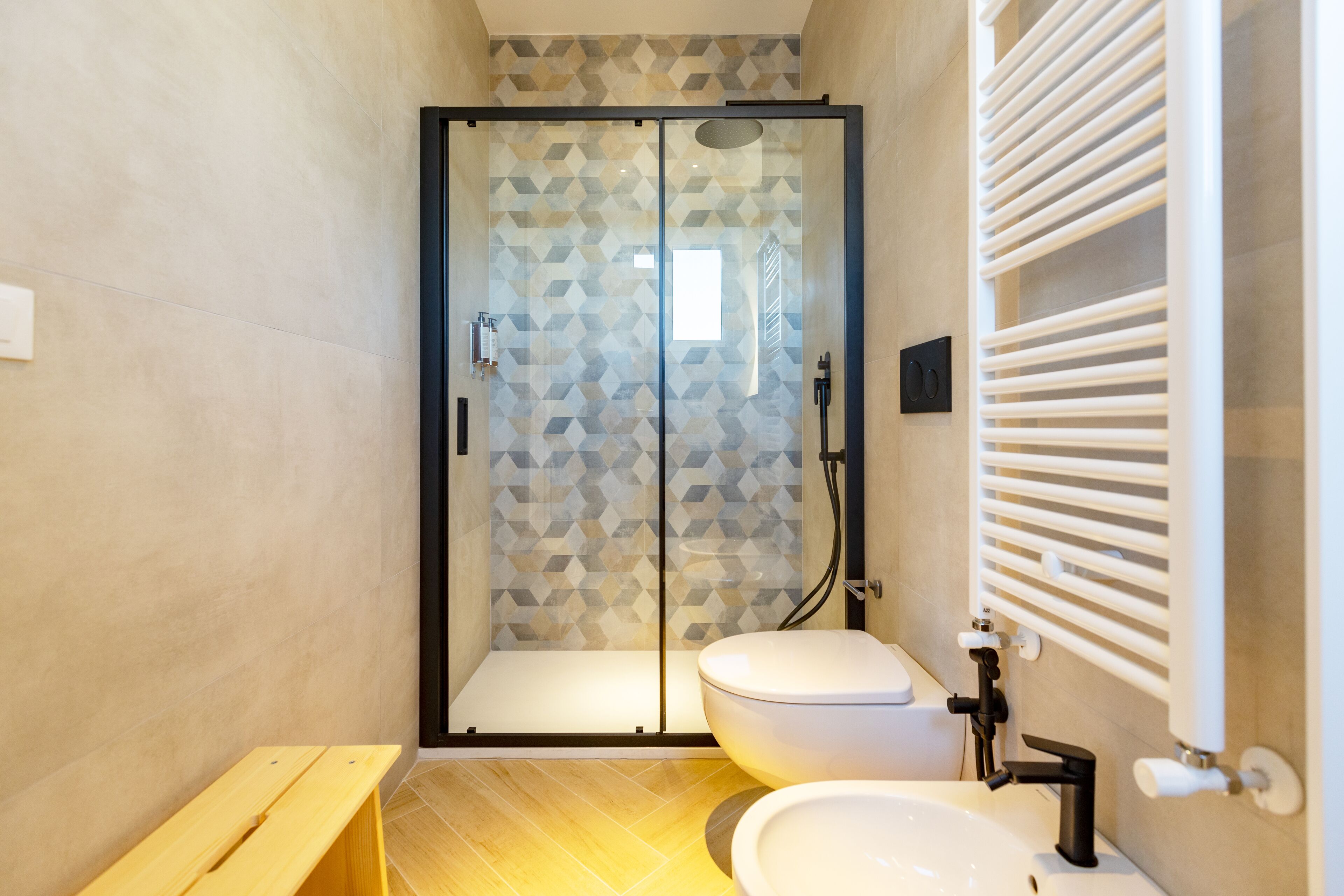 A modern bathroom with a glass-enclosed shower, a toilet, and a sink.