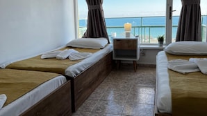 A hotel room with two beds, a small table, and a view of the sea. - Sunny Varshava Hotel (Golden Sands)