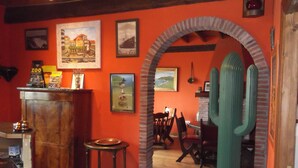 A dining area with a brick archway, wooden furniture, and a table with chairs.