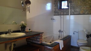 A bathroom with a sink, mirror, shower, and toilet.