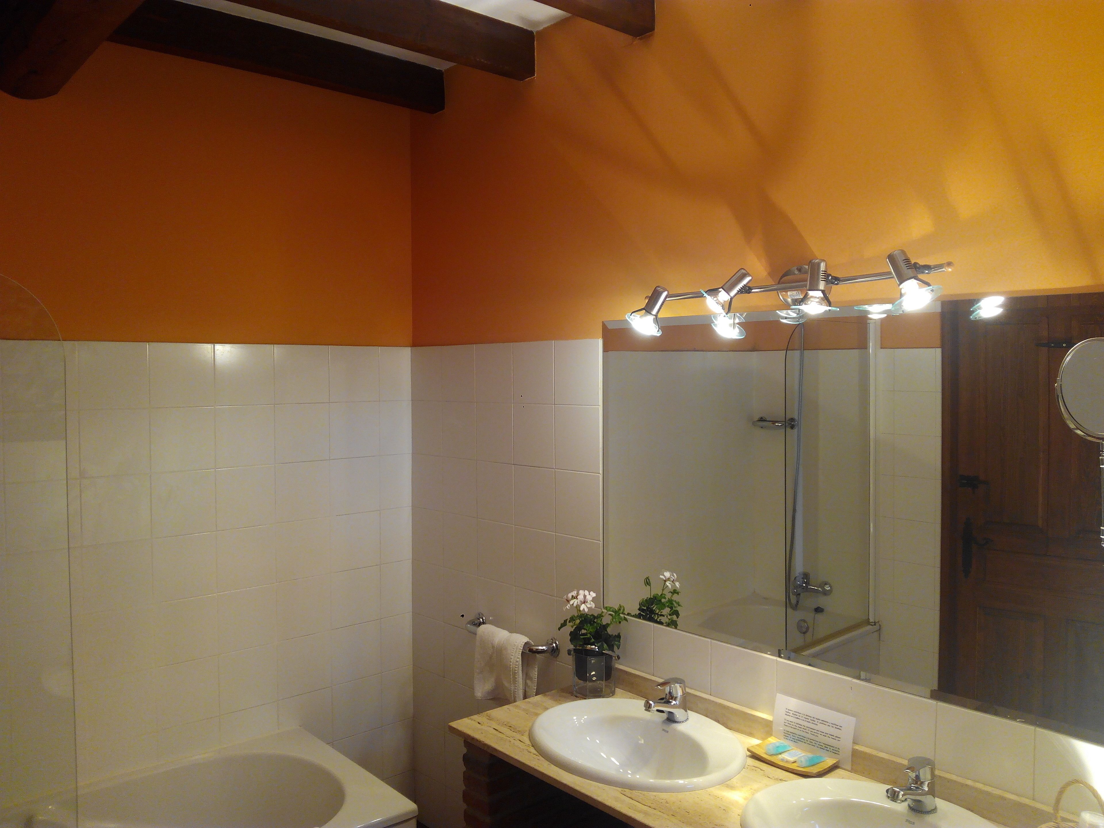 A bathroom with a bathtub, two sinks, a mirror, and a towel rack.