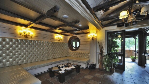 A room with a tufted sofa, a coffee table, and wall-mounted lighting. - Hotel Villa Danilo (Gamberale)