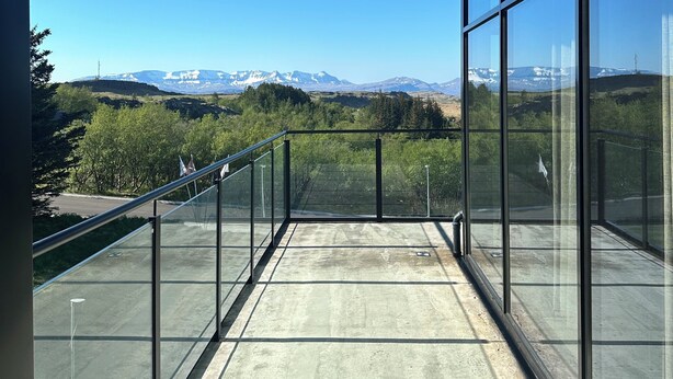 Un balcón con vistas a montañas y un cielo despejado.