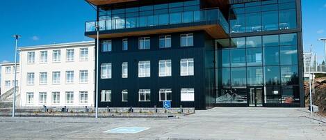 A modern building with a glass facade and a wooden upper level.