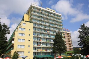 A multi-story hotel with balconies, a prominent sign, and a clear sky. - Varshava Hotel (Golden Sands)