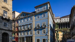 En byggnad med flera våningar, en blå fasad, flera balkonger och en skylt som visar att det är Ribeira Porto Hotel.