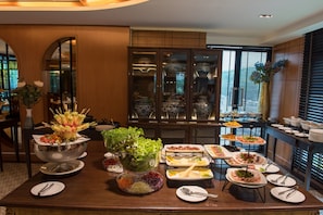 A buffet setup with various food items and a decorative centerpiece. - Bay Beach Resort (Pattaya)