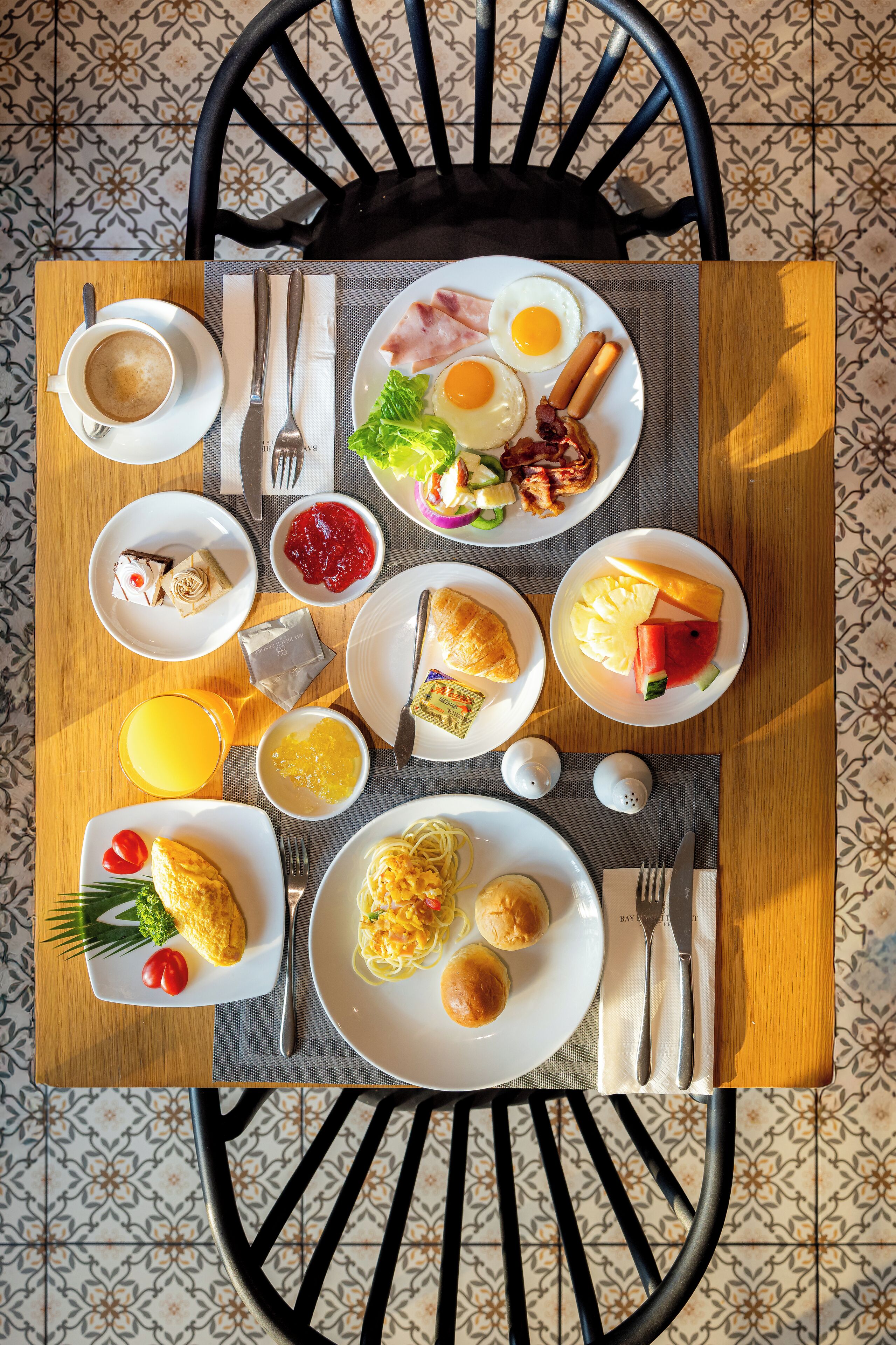 Une table de petit-déjeuner avec divers plats, notamment des œufs, des toasts et des fruits.