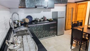 A compact kitchen with a sink, stove, and dining area. - Apartment 3 Rooms city center Fes (Fes)