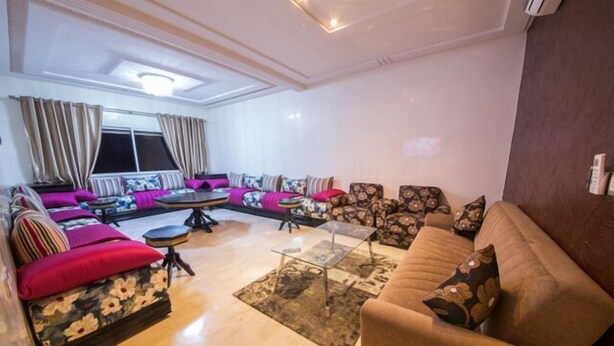 A modern living room with a sofa set, a coffee table, and a patterned rug. - Apartment 3 Rooms city center Fes (Fes)