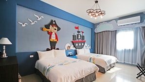 Un dormitorio con dos camas, un mural en la pared, aire acondicionado y una ventana con cortinas.