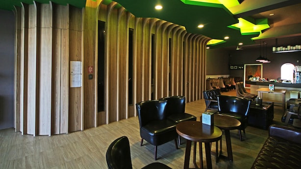 Un interior moderno con separador de madera, asientos de cuero y una zona de bar.