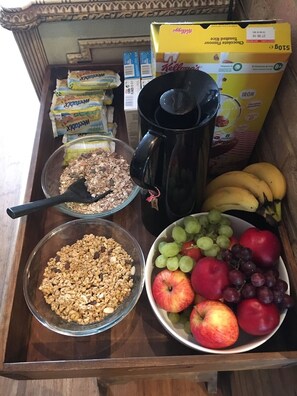 A breakfast tray with cereal, a coffee pot, and fresh fruits. - Rooms at Number One (Broadstairs)