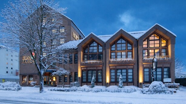 A hotel with a traditional architectural style, featuring large windows and a snow-covered exterior. - Leine Hotel (Pattensen)