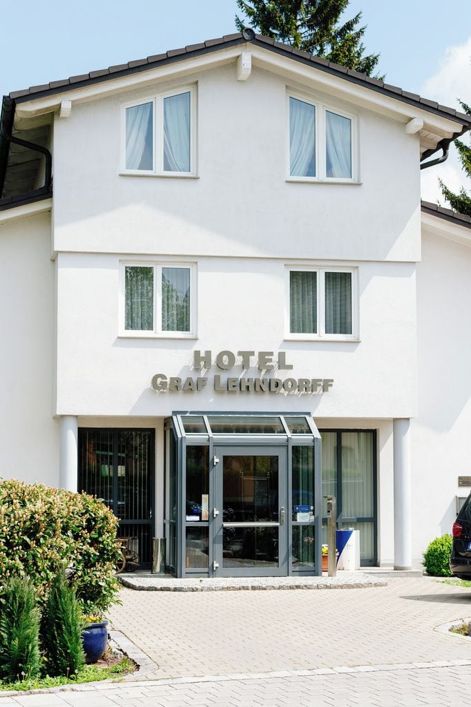 Ein zweigeschossiges Gebäude mit einem Schild, auf dem 'HOTEL GRAF LEHNDORFF' steht.