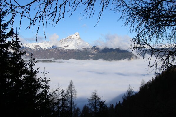 A mountain peak with snow, surrounded by trees and clouds. - Hotel Alpenrose (La Valle)