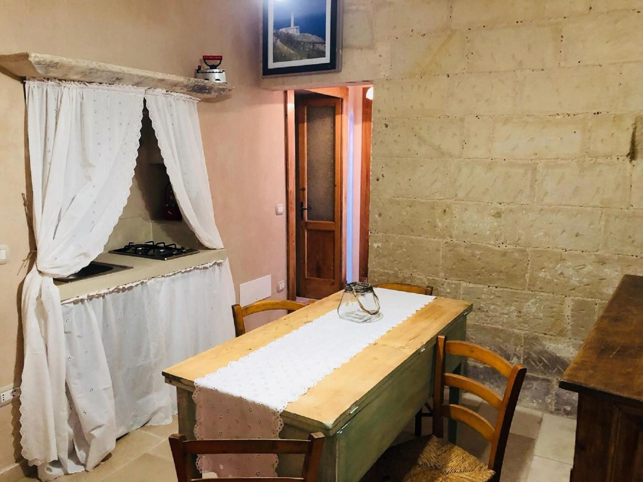 Una cocina rústica con estufa a gas, mesa y sillas de madera.