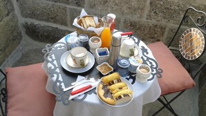 A table set with breakfast items including bread, pastries, and a glass of orange juice. - Borgoincorte (Martano)