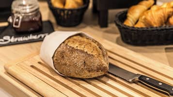 A loaf of bread on a cutting board with a knife beside it.