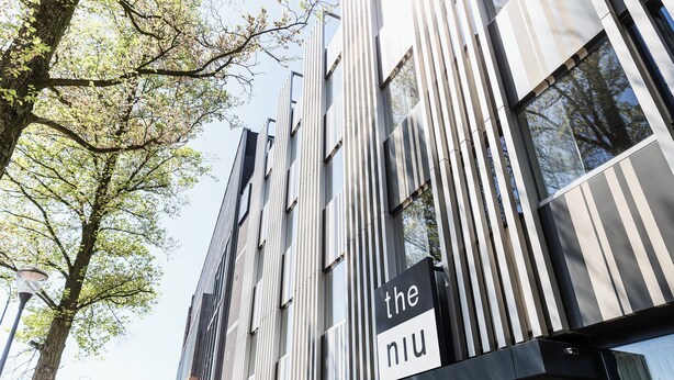 A modern building with vertical lines and a sign that reads "the niu". - Holiday Inn - the niu, Dairy Haarlem by IHG (Haarlem)