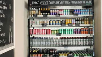 Ein Getränkeautomaten mit einer Auswahl an Getränken, darunter Limonaden, Bieren und Spirituosen, wobei die Preise erkennbar sind.
