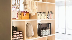 A wooden shelf with various items including a plant, a basket, and neatly arranged products. - Holiday Inn - the niu, Dairy Haarlem by IHG (Haarlem)