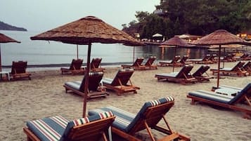 Sulla spiaggia, lettini da mare, ombrelloni, teli da spiaggia