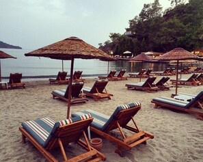 On the beach, sun loungers, beach umbrellas, beach towels - The Bay Beach Club (Fethiye)