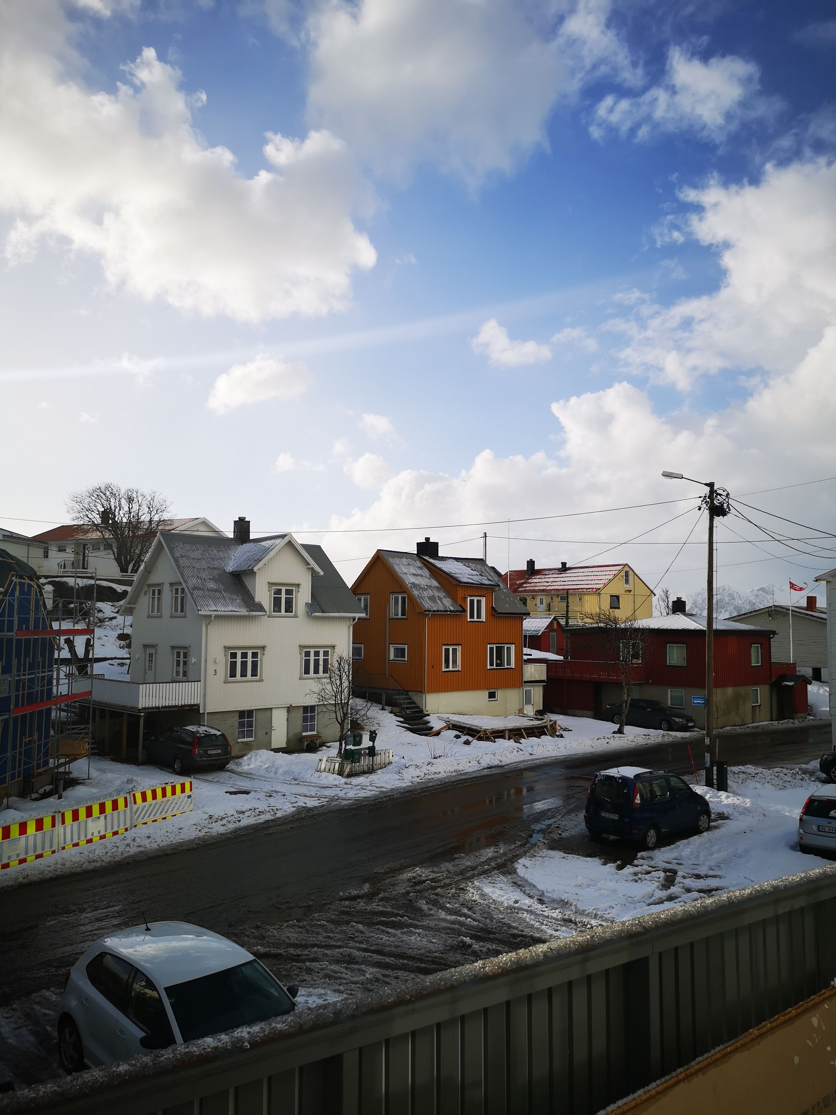 Une rue résidentielle bordée de maisons, avec une route et un pont.