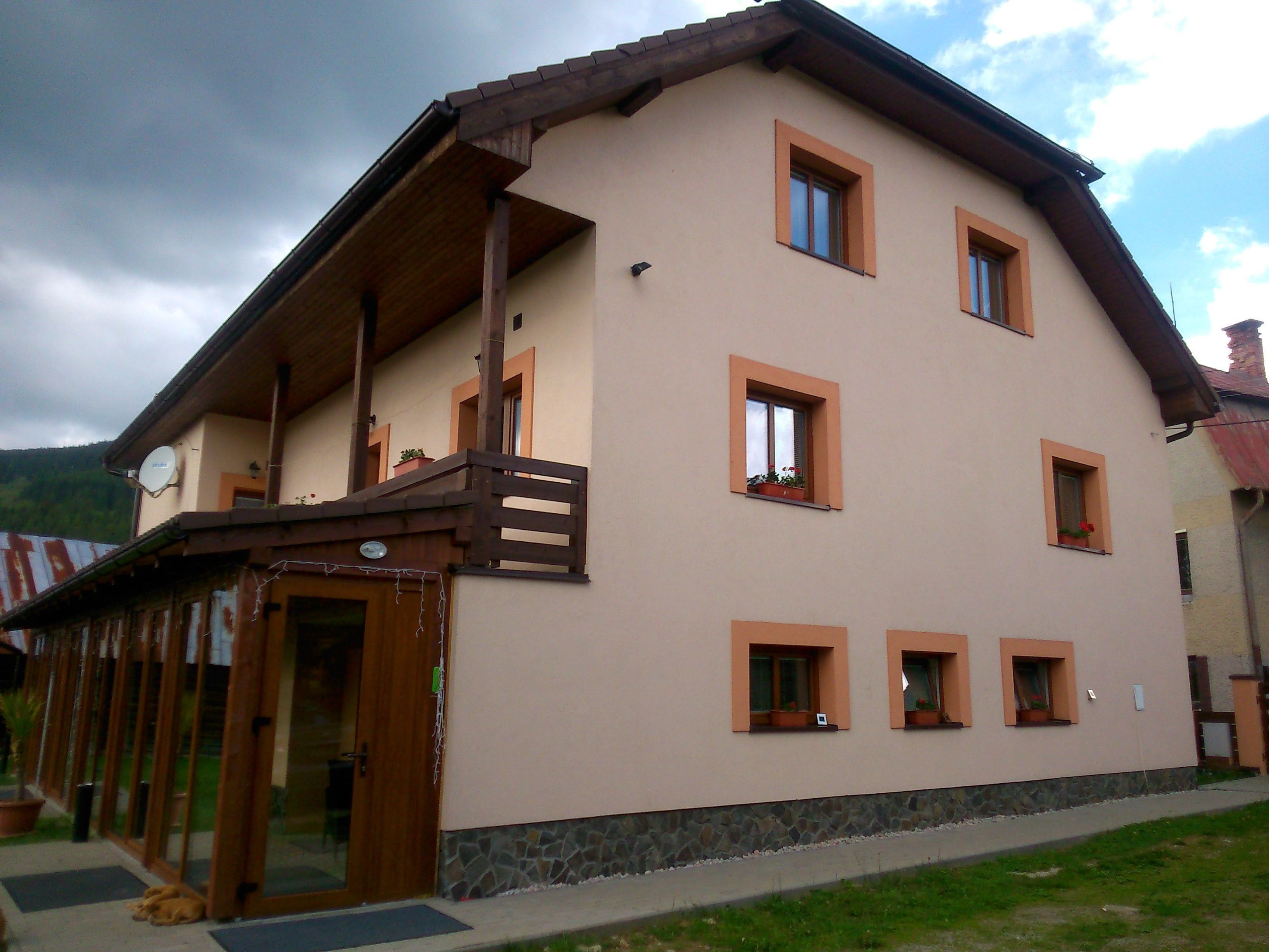 Ein zweistöckiges Gebäude mit Balkon, zahlreichen Fenstern und einem Stein Fundament.