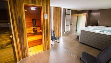Relax in a serene spa room with a sauna, hot tub, and massage chair.