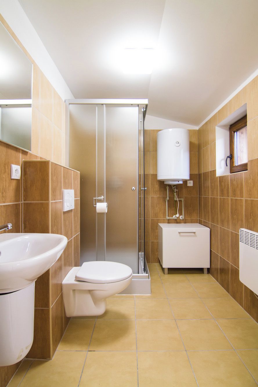 Un baño con inodoro, lavabo y ducha.