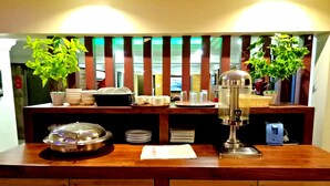 Un bar pour prendre le petit-déjeuner, équipé d’une machine à café, d’assiettes, de bols et de tasses.