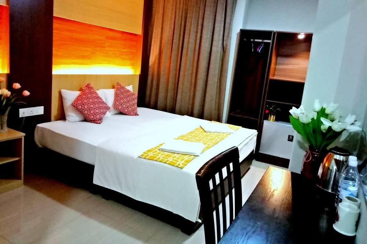 A hotel room with a bed, bedside table, and a nightstand.