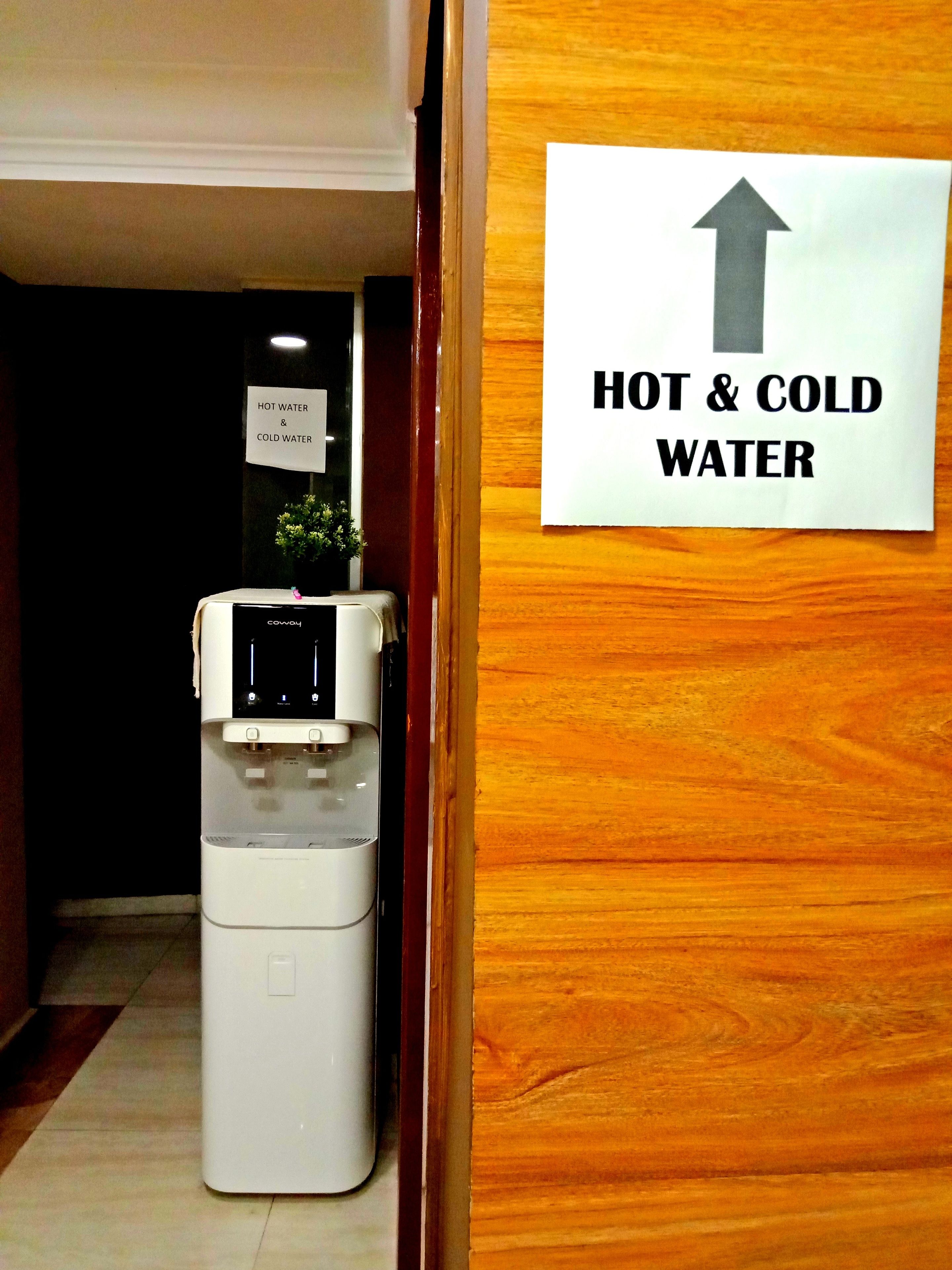 Dispensador de agua con un cartel que indica agua caliente y fría.