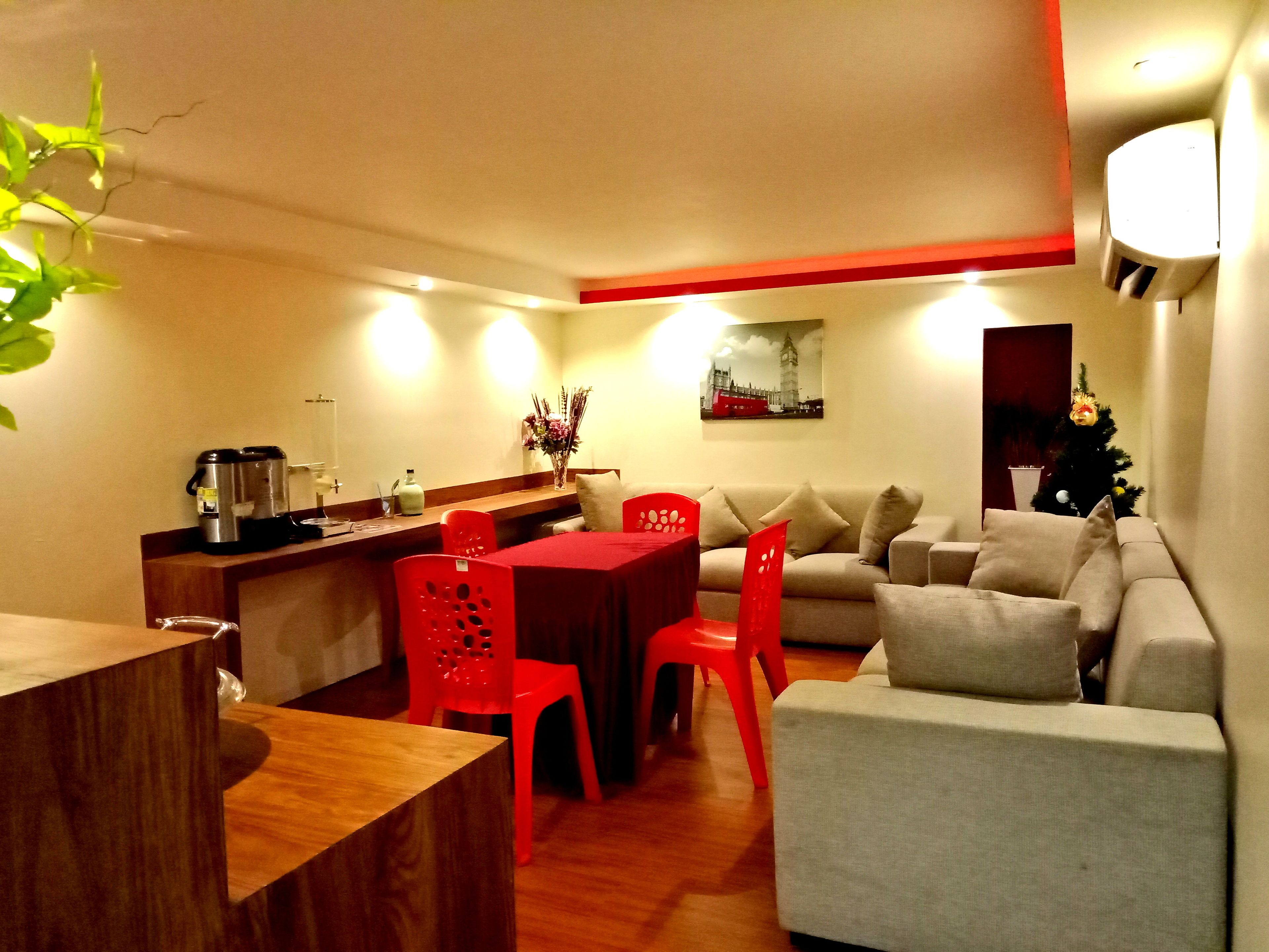 Un espacio habitable compacto con comedor, sofá, máquina de café y un árbol de Navidad.