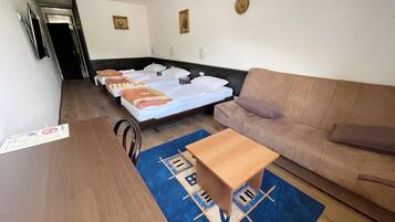 Una habitación de hotel con una cama, un sofá, una mesa de madera y una alfombra azul.