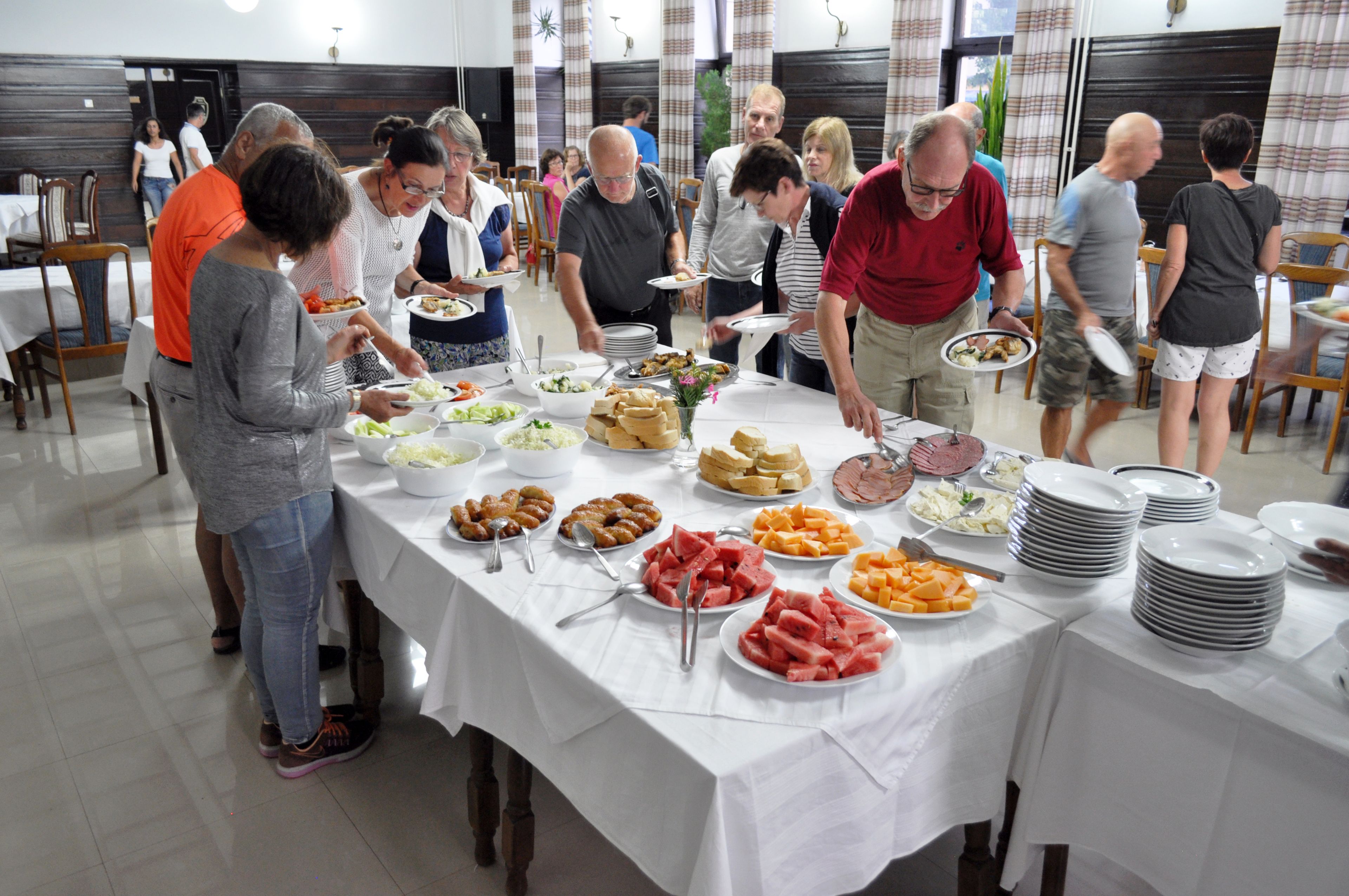 Ein reichhaltiges Buffet mit verschiedenen Speisen, an dem Gäste sich selbst bedienen.