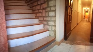 A staircase with white steps and wooden handrails, leading to a door with a glass panel. - Hotel La Font de Lauro (Saumane-de-Vaucluse)