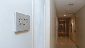 Un couloir avec une porte portant le numéro « 909 » et un mur de couleur claire.