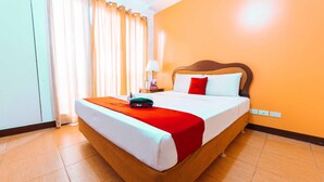 Une chambre d’hôtel avec un lit, des rideaux, une lampe et un panneau « Red Door ».