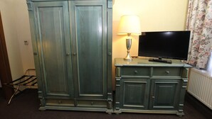 A room with a large wardrobe, a television on a cabinet, and a lamp. - Hotel Restaurant zur Linde (Pattensen)