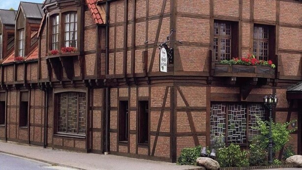 A traditional half-timbered building with a red-tiled roof, multiple windows, and a sign indicating it is a hotel. - Hotel Restaurant zur Linde (Pattensen)